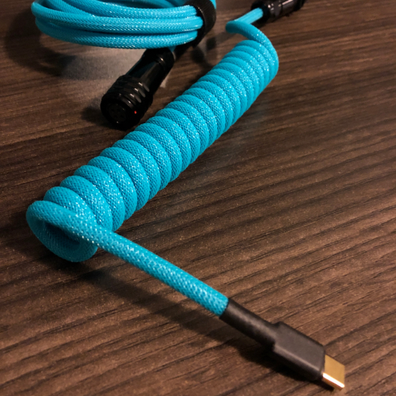 Artisan blue coiled cable closeup on a wooden desk