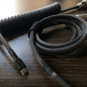 Close up of a black USB keyboard cable on a wooden desk