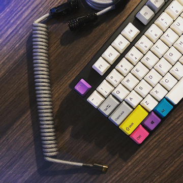 closeup o fa coiled USB cable and a colourful keyboard