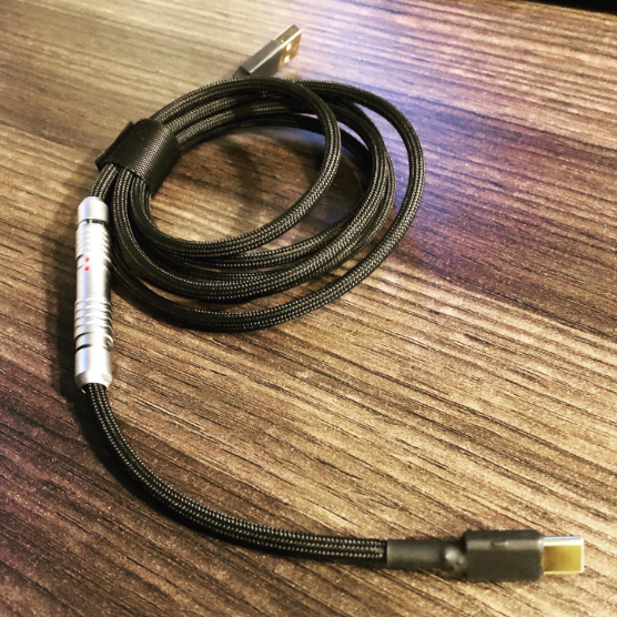 Straight black USB power cable on a wooden desk